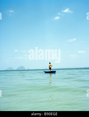 A man in a small boat on the blue sea Thailand. Stock Photo
