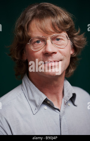 studio portrait of adult man with long hair and eyeglasses Stock Photo