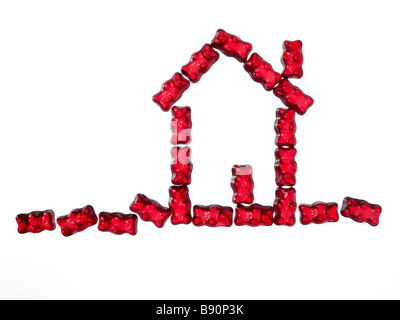 red jellybabies formed as a house on white background