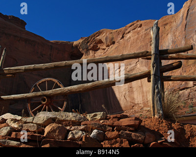 Wagon wheel and post-and-rail fence against the backdrop of a magnanimous butte in the Southwest USA Stock Photo