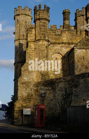 Battle Abbey old stone walls & turrets in late afternoon sun with old red phone box Stock Photo