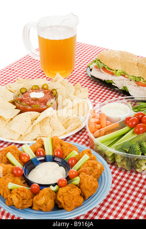 Table set with party snack food platters and a pitcher of beer  Stock Photo