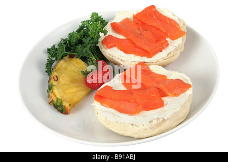 A bagel with cream cheese and smoked salmon lox and garnished with fruit Isolated on white Stock Photo