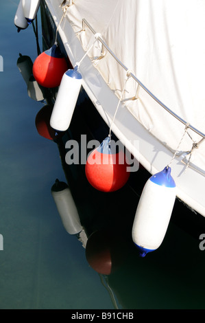Fenders hang from the side of a boat Stock Photo