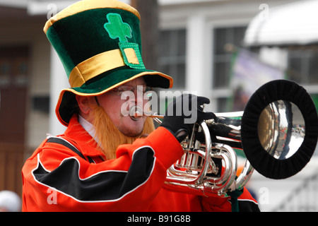 Trumpet player with a fake orange beard and shamrock hat in a St. Patrick's Day Parade Stock Photo