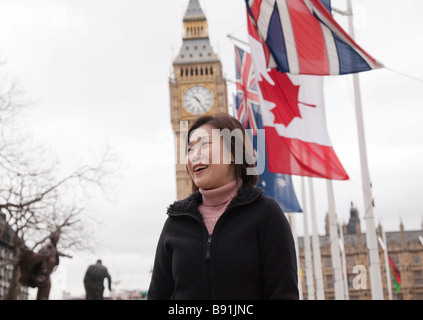 Asian oriental tourist female in 20s / 30s visiting London, with Big Ben in background Stock Photo
