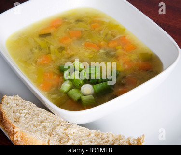 Homemade vegetable soup with chopped spring onion and onion bread. Stock Photo