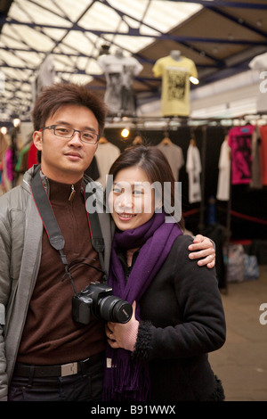 Asian oriental tourist couple in 20s / 30s visiting London, in Greenwich market Stock Photo
