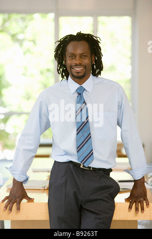Businessman smiling and leaning against his desk Cape Town Western Cape Province South Africa Stock Photo