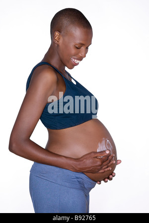Side view of pregnant woman moisturising her tummy Studio Shot Stock Photo