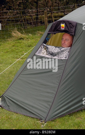 A man looking out of a tent Stock Photo