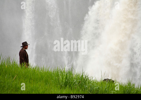 Man standing in front of main waterfall of Victoria Falls, Livingstone, Zambia Stock Photo