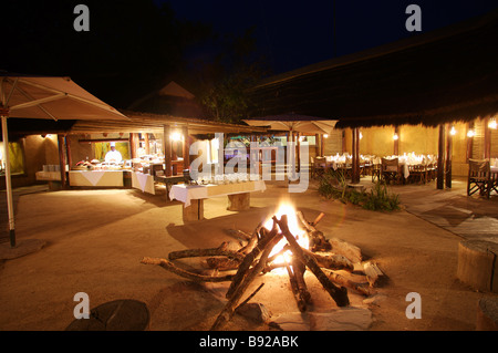 Bonfire in the middle of the lodges with buffet set up in background Kapama Lodge Limpopo Province South Africa Stock Photo