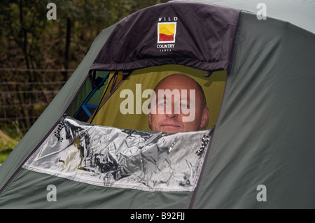 A man looking out of a tent Stock Photo