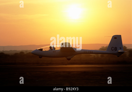 A glider, silhouetted by a setting sun, coming in to land at Évora airfield, in southern Portugal's Alentejo province Stock Photo