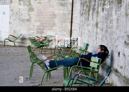 Man catches a bit of shut-eye on a clear winter's day in Tuileries, Paris Stock Photo