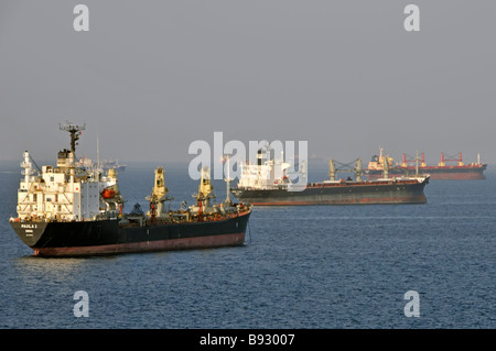 Unladen shipping in heat haze bulk carriers & oil tankers coastal waters anchorage off UAE Fujairah bunkering port Gulf of Oman near Straits of Hormuz Stock Photo