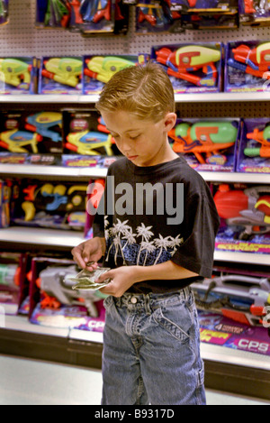 Checking his allowance money carefully a 10 year old boy prepares to make a purchase in a store toy department Stock Photo