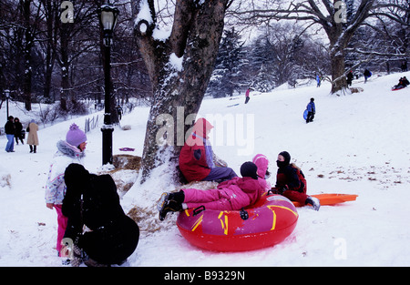 New York City Central Park in a snowstorm children playing on Cedar Hill USA. Family fun Stock Photo
