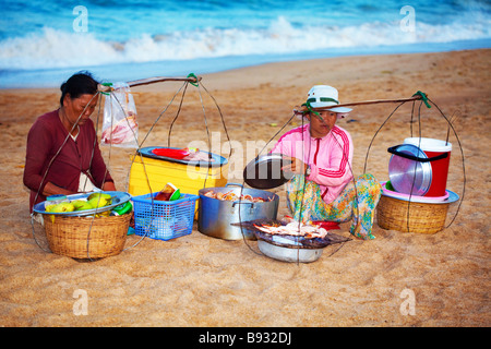 two vietnamese woman sell grilled seafood on the beach Stock Photo