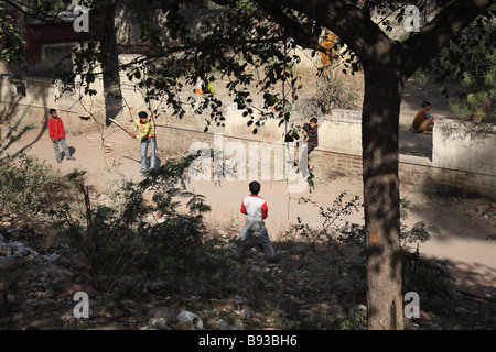 Young boys play a game of cricket by the side of the road near New Delhi Train Station, Delhi, India. Stock Photo