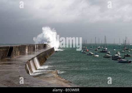 Crashing waves over the breakwater of Alderney on a stormy day Stock Photo