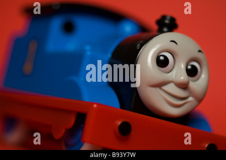 A close up of a child's toy 'Thomas the Tank Engine' on a red background. Stock Photo