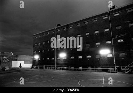 Prison officer dog handler patrols the perimiter of Prison at night Pentonville Prison LOndon England Stock Photo