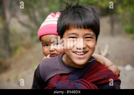 Annapurna Nepal 19 March 2008 Young boy carrying his baby sister while trying to tease trekkers for food Stock Photo