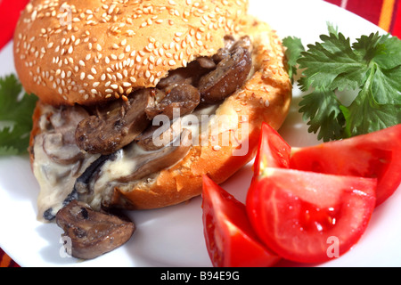 A vegetarian burger made with mushrooms and cheese and garnished with tomato Stock Photo