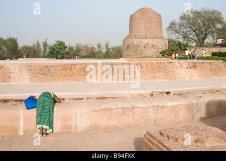 Praying Devotee in front of the Dhamekh stupa Isipatana deer park Sarnath Uttar Pradesh India Stock Photo