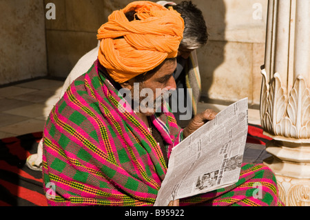 A man reads his newspaper inside the famous Rat temple of Karnimata located in Dishnoke ,south of the city of Bikaner, Rajasthan Stock Photo