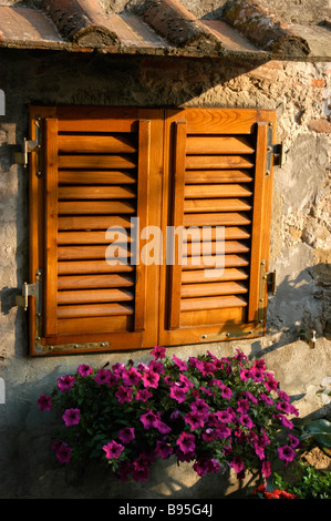 A shuttered window to prevent the heat of the day entering a house. Stock Photo