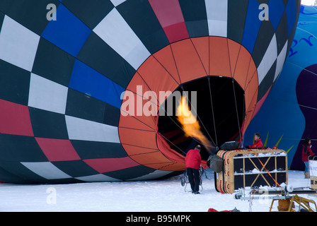 Switzerland, Canton de Vaud, Chateau d'Oex, Hot Air Balloon Festival.  Flame being directed into balloon to heat air inside. Stock Photo