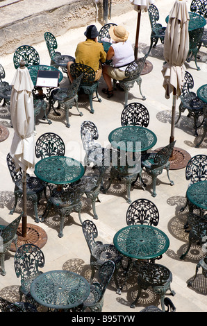 MALTA Valletta Two people sitting at a table amongst other wrought iron tables and chairs in cafe below Upper Barrakka Gardens Stock Photo
