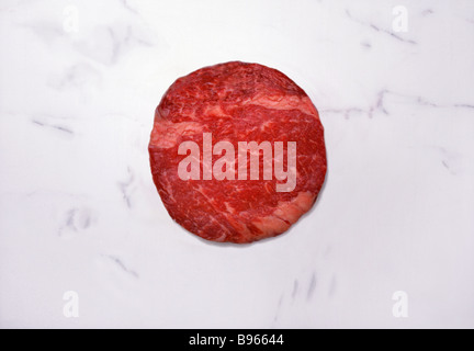 Round raw beef on a marble slab Stock Photo