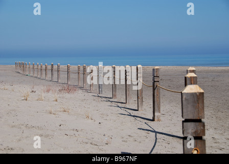 An early season line of posts installed on a Toronto beach to separate sensitive grasslands from the public recreational area.. Stock Photo
