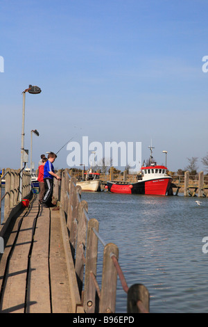 Boys fishing from the pier in Rye Harbour East Sussex  England Stock Photo