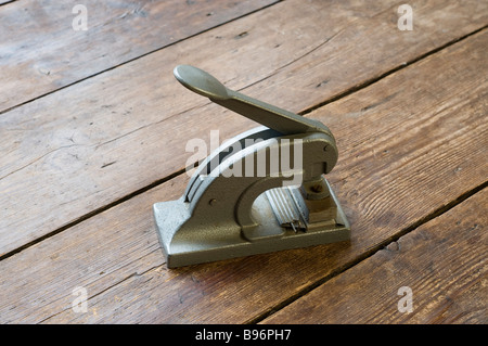 Old company seal press for embossing documents on a wooden floor Stock Photo