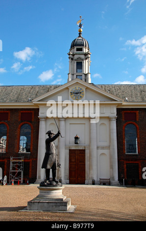 Statue of a Chelsea Pensioner in the grounds of the Royal Hospital, Chelsea, London. The Great Hall & Chapel block are behind. Stock Photo