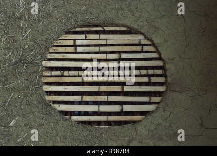 Window in adobe wall, covered by bamboo rods Stock Photo
