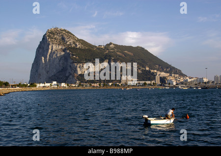 View from Spain. Across sea bay. Boat on water. Large rocky edifice. Buildings town. Stock Photo