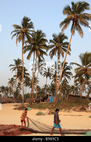 India Goa Colva beach fishermen with fishing net palms scenery Stock Photo