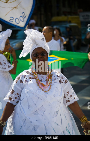 A traditional bahian mae-de-santo spiritual woman in front of a brazilian flag at a candomble celebration in Paris, France Stock Photo