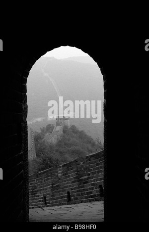 Looking out from arched doorway of room perched atop Great Wall of China Stock Photo