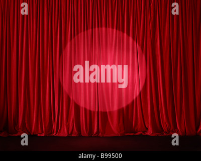 Red stage curtain spotlit Stock Photo