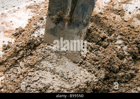 A spade is used in a chopping action to mix water with cement/ballast ...