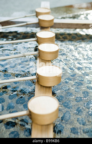 Hishaku ladles lined up in basin of traditional Shinto Chozuya, Japan Stock Photo