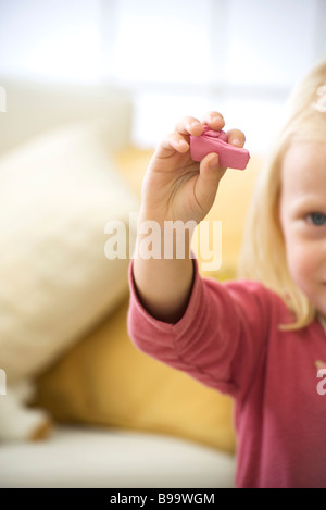 Little girl holding up handful of pink clay, cropped Stock Photo