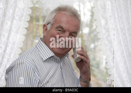 Pensioner using a telephone, making a phone call Stock Photo